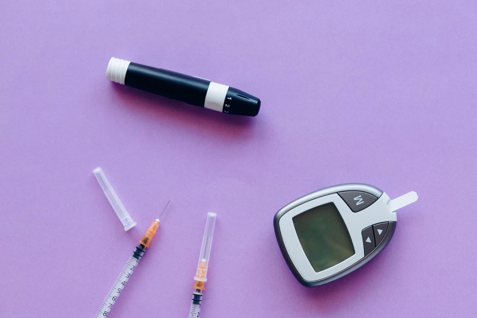 An insulin pen and diabetes medication kit laid out on a table, representing a type 2 diabetes prescription