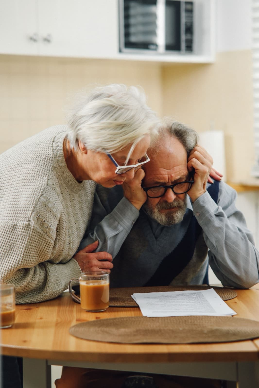 A worried senior couple reviewing a prior authorization denial letter together at their kitchen table